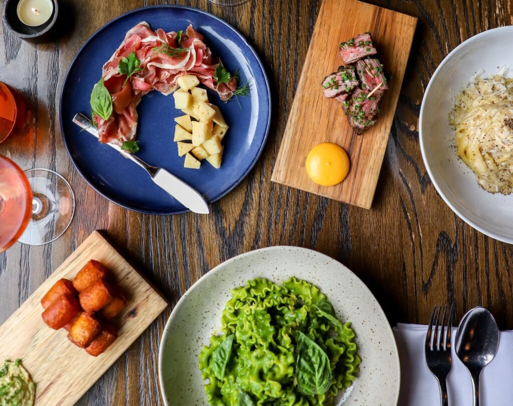 An aerial view of a table of dishes from Juniper, an Italian restaurant in Austin near the Heywood Hotel.