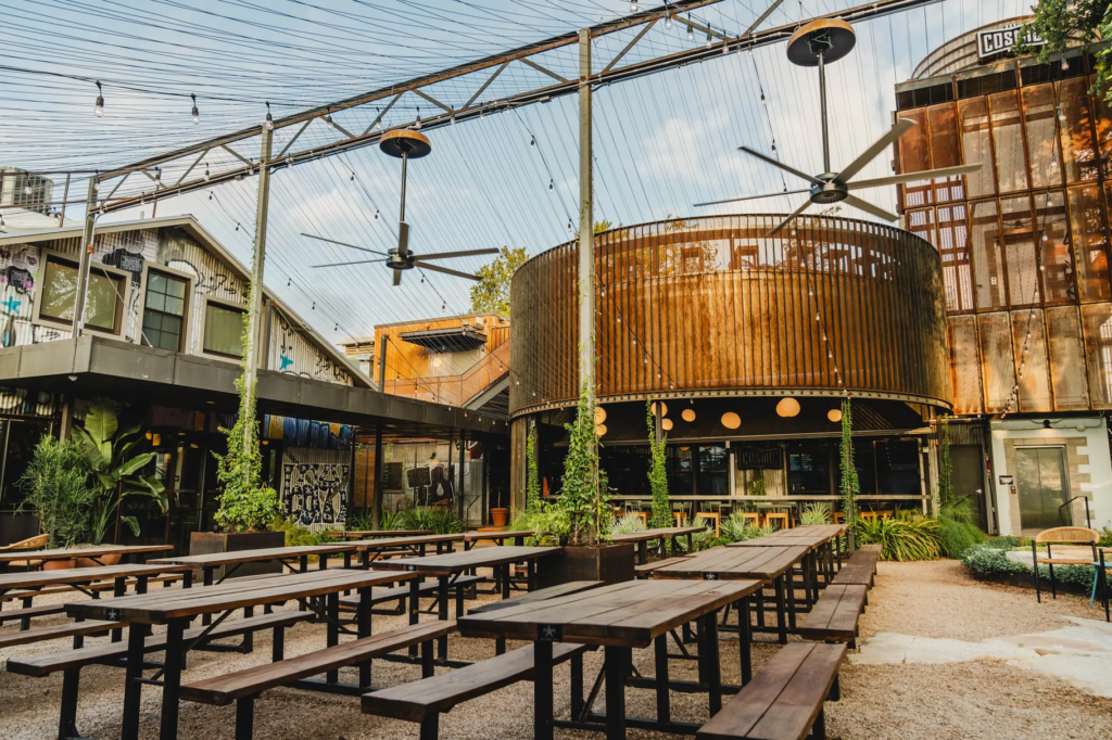 Outdoor tables on the industrial-style patio at Cosmic Saltillo, one of the Heywood Hotel's recommendations for the best East Austin coffee shops.